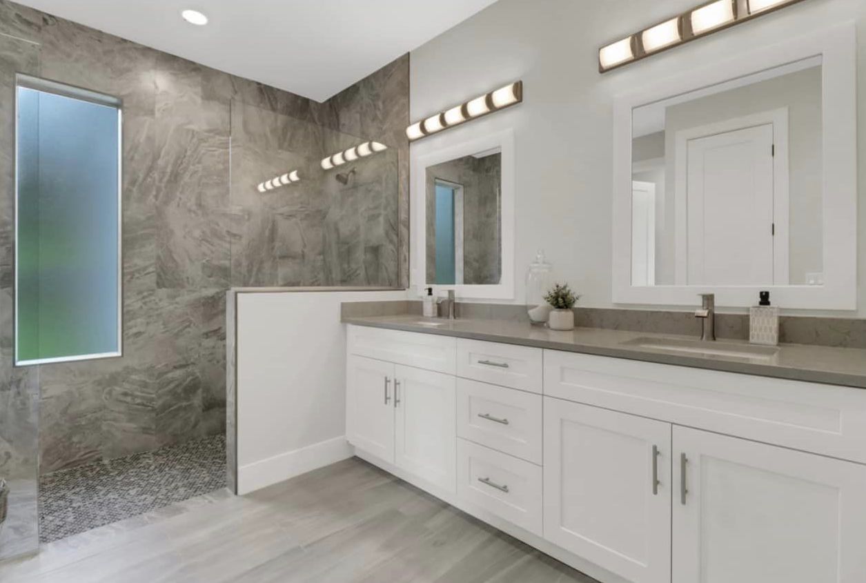 Naples bathroom remodel with gray stone-look wall tile and white shaker vanity